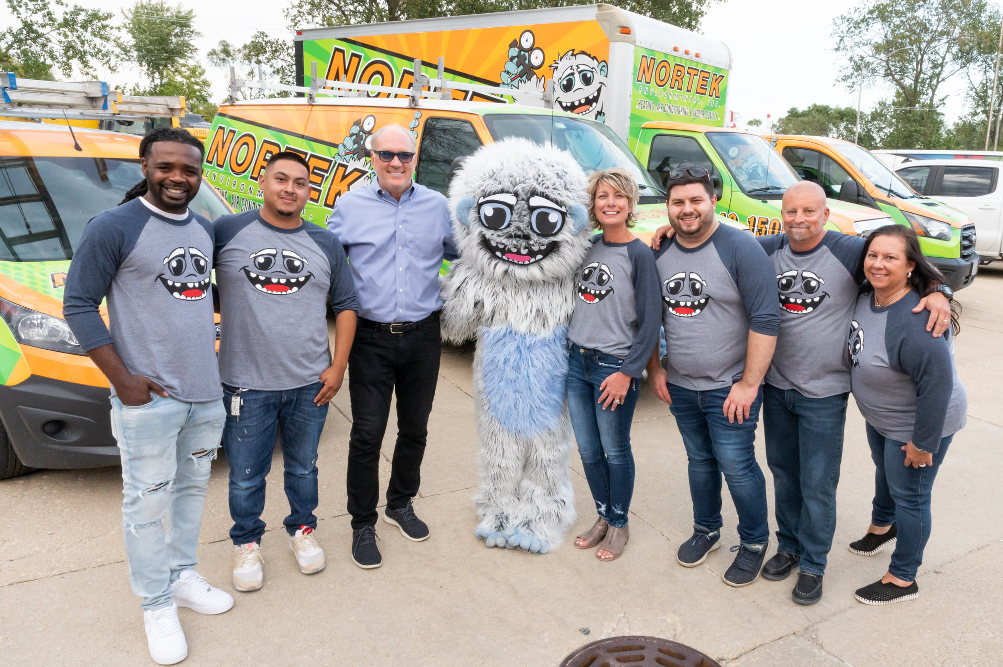 The Nortek Environmental, Inc. team posing with Norton in front of their vans in Bolingbrook