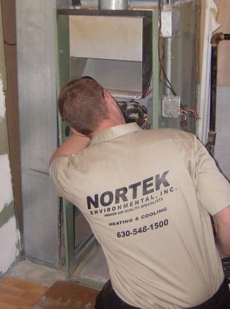 A Nortek technician checking the blower during an AC service call in Naperville.